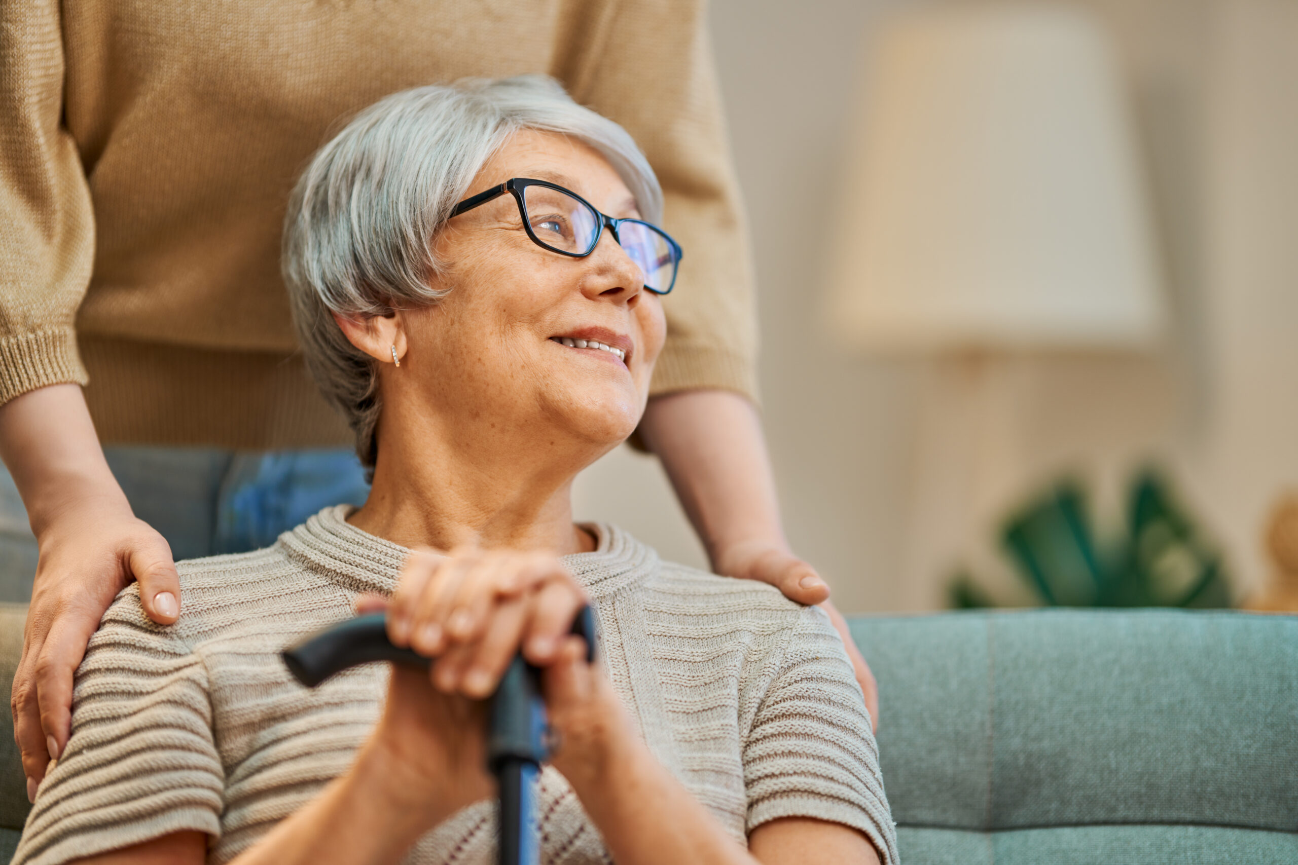 Happy patient and caregiver spending time together. Senior woman holding cane.